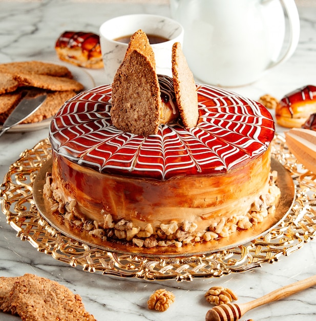 Free photo side view of caramel cake with cookies on silver tray