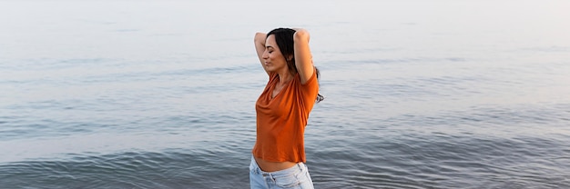 Side view of carefree woman posing by the beach