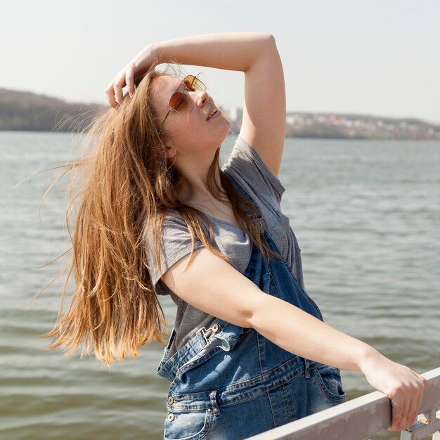 Side view of of carefree woman posing by the lake