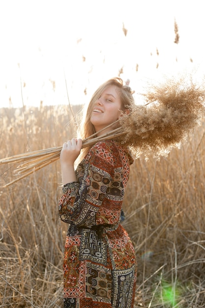 Free photo side view of carefree woman posing in nature field