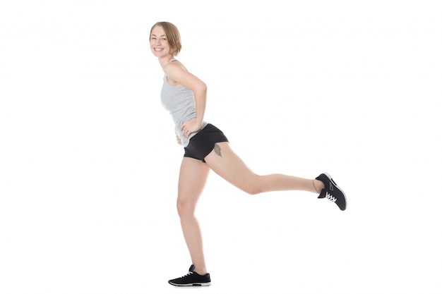 Side view of cheerful girl doing stretching