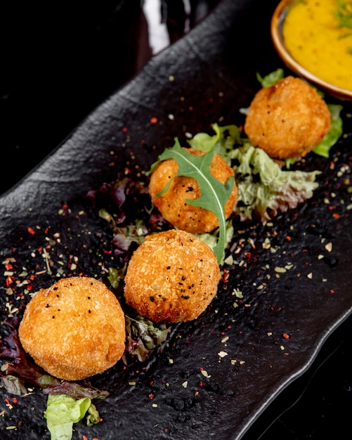 Free photo side view cheese balls with spices and herbs