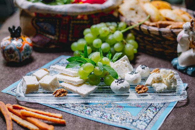 Side view of cheese plate with grapes and walnuts