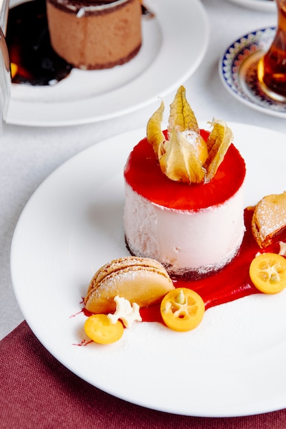 Side view of cheesecake topped with kumquat on the table