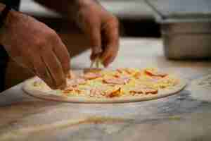 Free photo side view chef baking delicious pizza