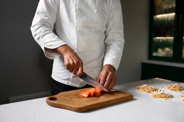 Free photo side view chef cutting vegetable