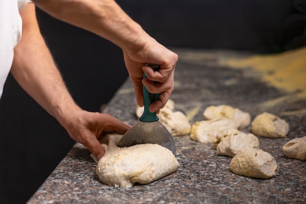 Cuoco unico di vista laterale che prepara pizza