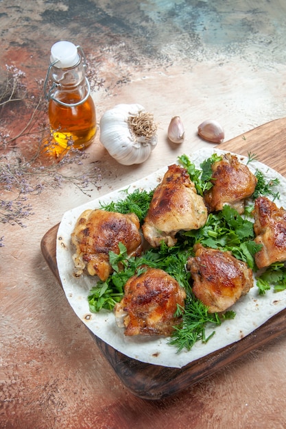 Side view chicken chicken with herbs on lavash next to the bottle of oil garlic