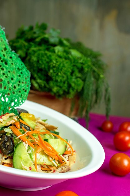 Free photo side view of chicken salad with chopped fresh vegetables and black olives in a bowl