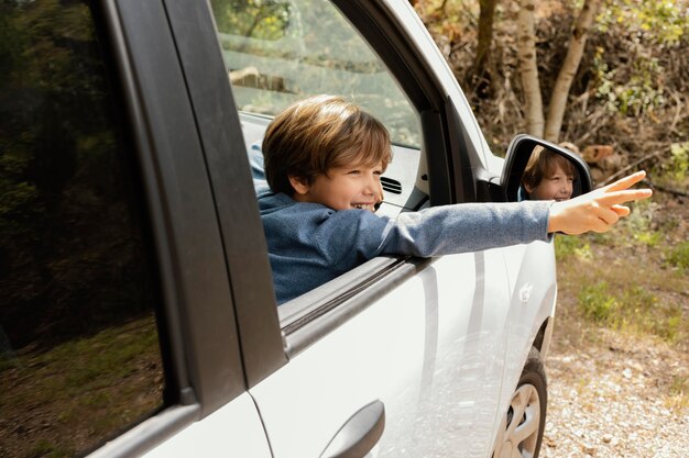 Side view child in car with arms showing peace sign