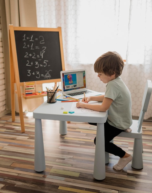 Vista laterale del bambino a casa che impara la matematica