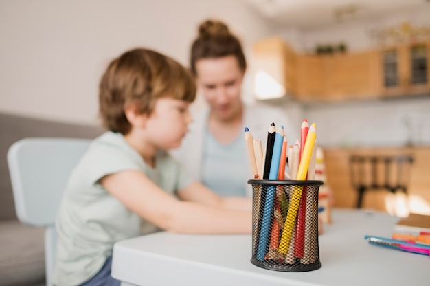 Foto gratuita vista laterale del bambino e tutor a casa prendendo una classe