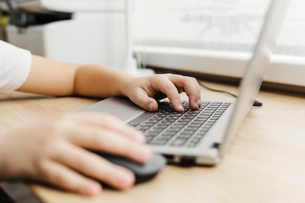 Side view child using a laptop