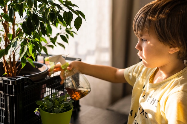 Free photo side view of child watering plants