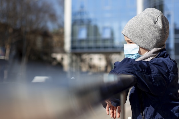 Side view of child wearing medical mask outside