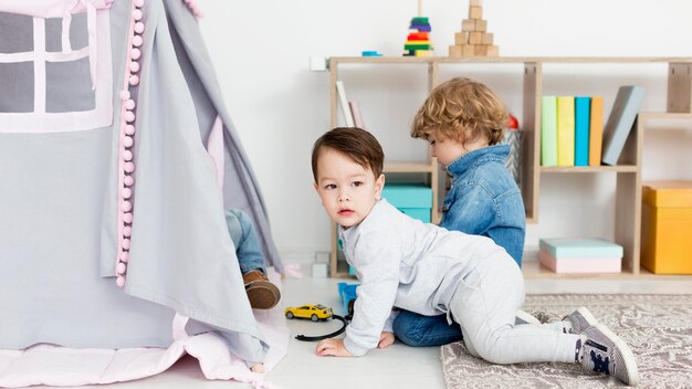 Side view of children outside tent with toys