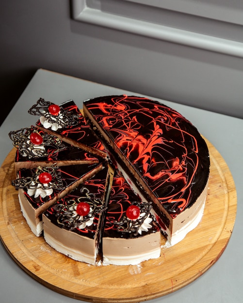 Free photo side view of chocolate cake on wooden platter