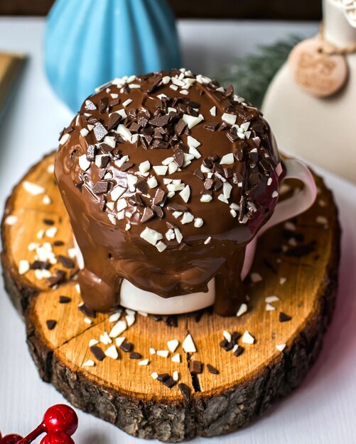 Side view of chocolate pudding cake with chocolate sprinkles in a cup on a wooden board