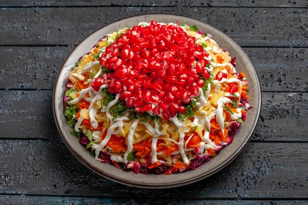 Side view Christmas food appetizing Christmas dish with seeds of pomegranate in the plate on the grey table