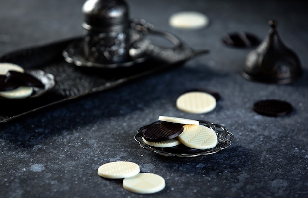 Side view of circle chocolate candies on a black table jpg