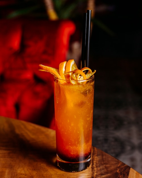 Side view of citrus cocktail with grapefruit and orange on a wooden table