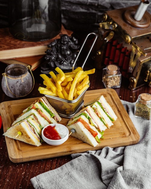 Side view club sandwich with french fries and ketchup with mayonnaise