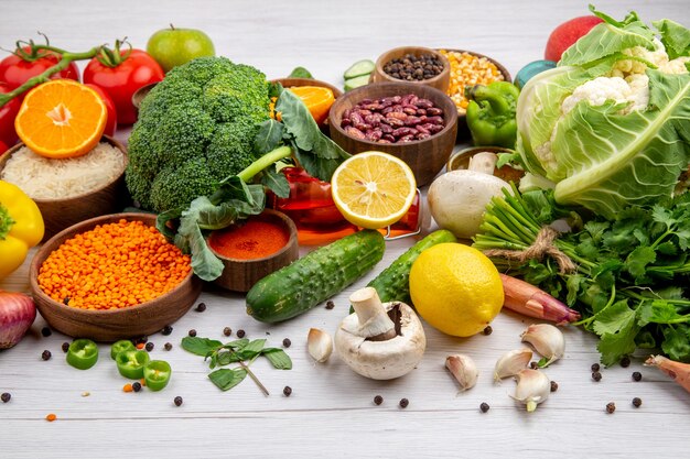 Side view of collection of fresh foods and spices vegetables on white background