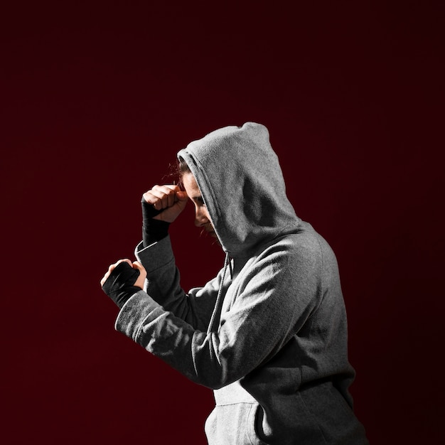 Side view combat position of a woman in hoodie