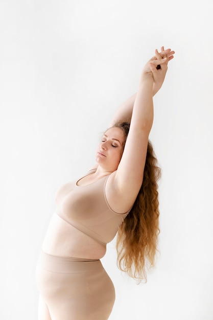 Side view of confident woman posing while wearing a body shaper