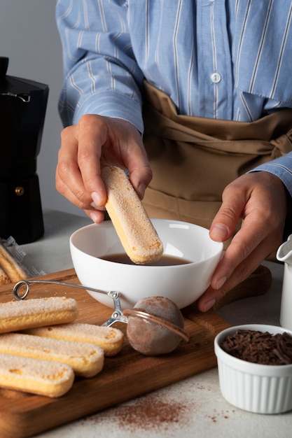 Side view cook holding ladyfinger