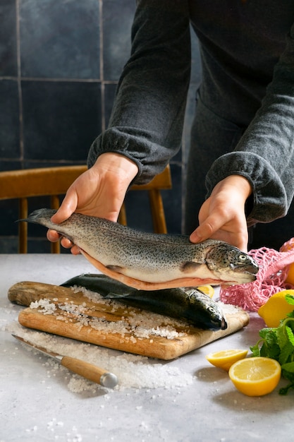 Side view cook preparing raw trout