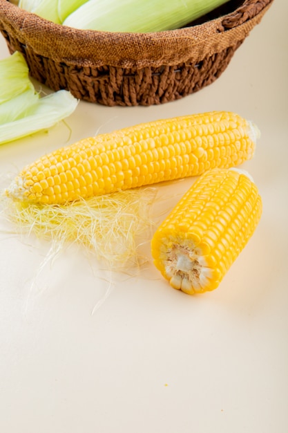 Side view of cooked corns on white table