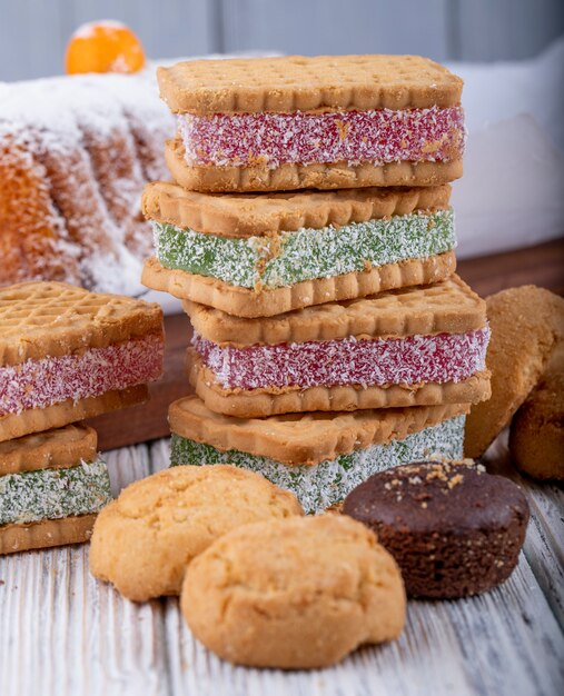 Side view of cookies with marmalade berry filling on a wooden tray