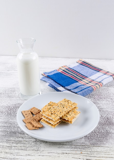 Side view cookies with milk on white wooden table and white background vertical 1