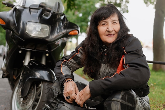 Foto gratuita donna anziana fresca di vista laterale con la motocicletta