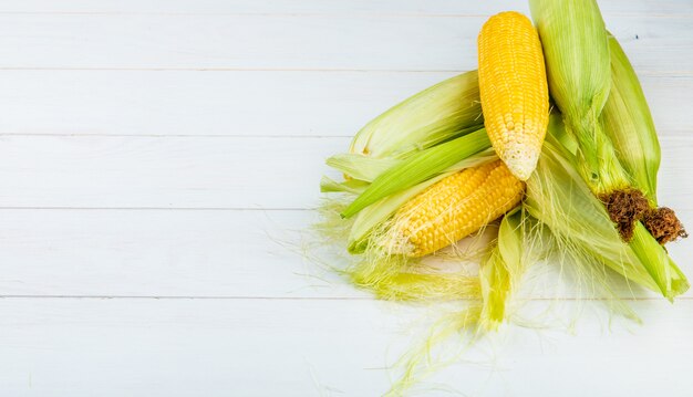 Side view of corn cob on wooden surface with copy space