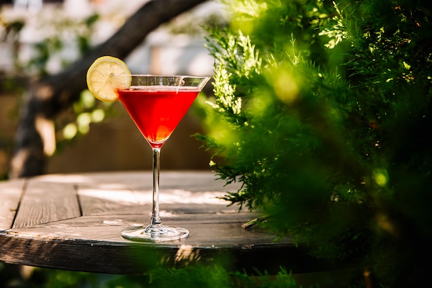 side view cosmopolitan cocktail with liquor and slice of lemon