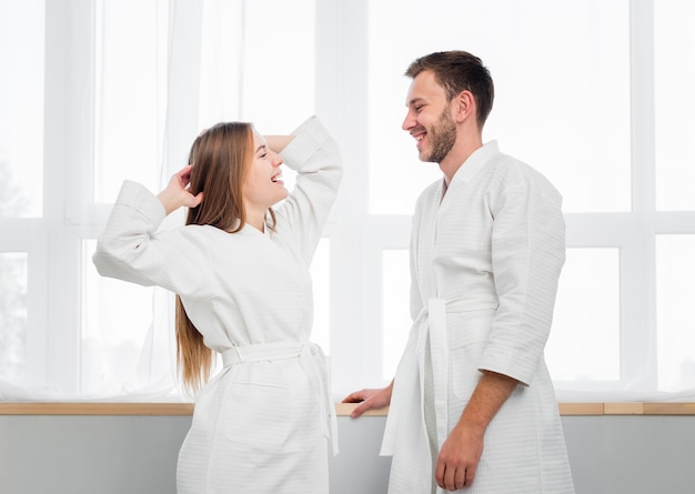 Side view of couple in bathrobes looking at each other
