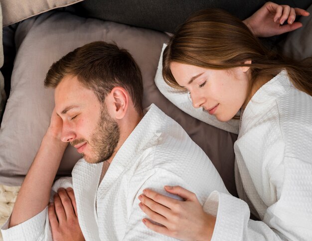 Side view of couple in bathrobes sleeping