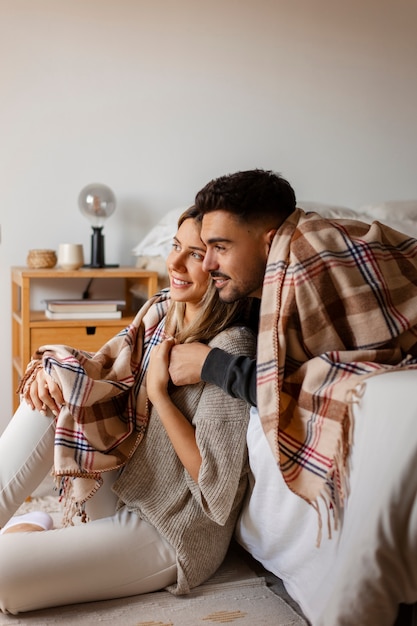 Free photo side view couple being affectionate indoors