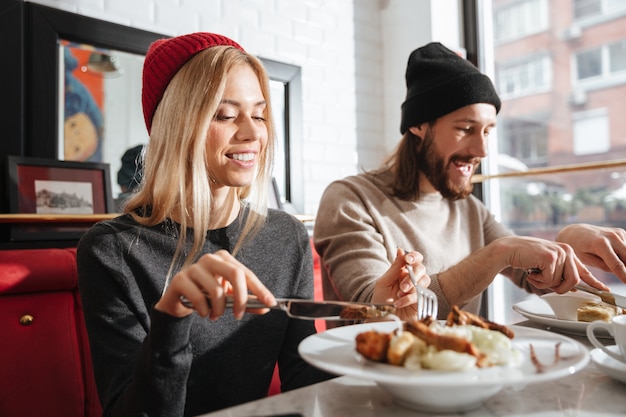 Side view of couple eating in cafe