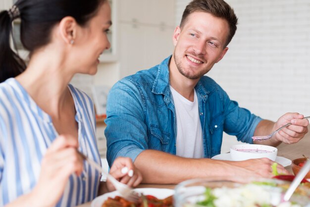 Foto gratuita coppie di vista laterale che mangiano insieme