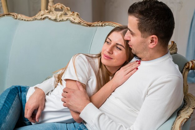 Side view of couple embraced on sofa