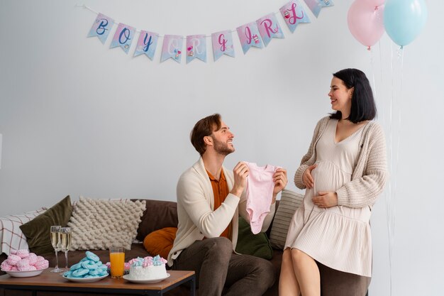 Free photo side view couple at gender reveal party