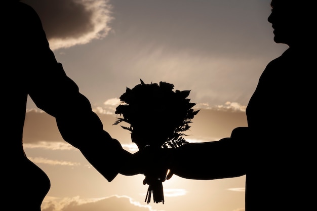 Side view couple holding flowers bouquet