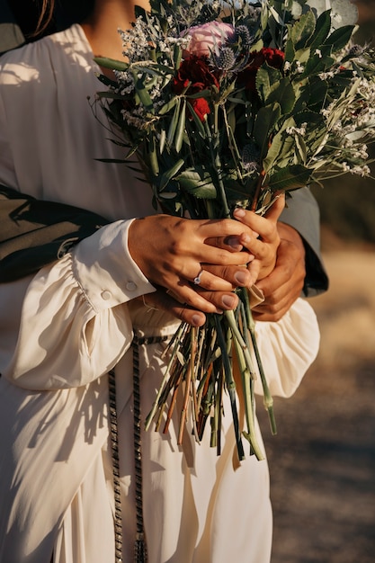 Free photo side view couple holding flowers bouquet