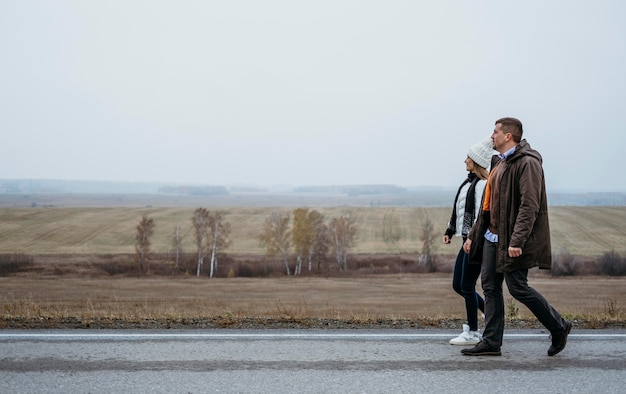 Free photo side view of couple holding hands on the road