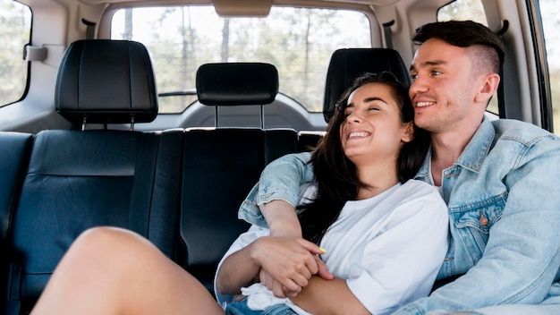 Free photo side view couple hugging in car