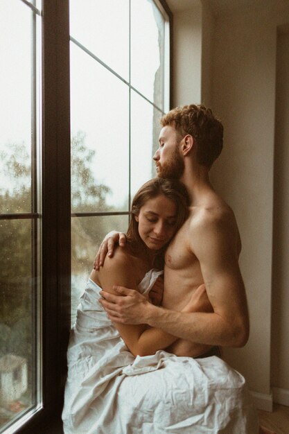 Side view couple hugging indoors