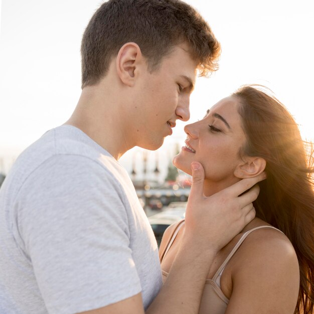 Side view of couple kissing at sunset